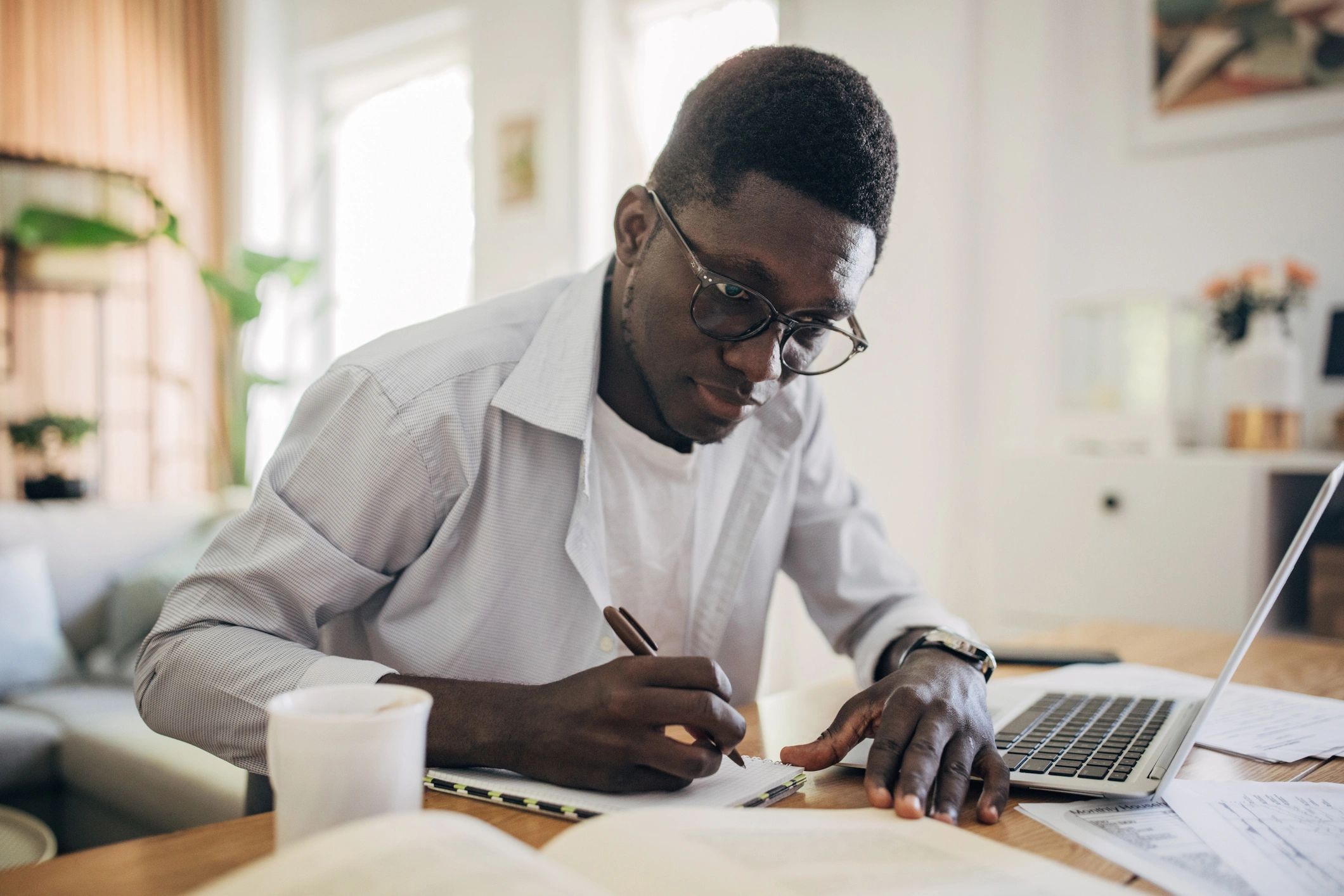 Doctoral student studying at home with notes and laptop